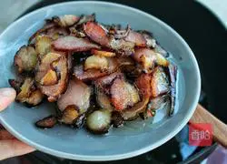 Illustration of how to stir-fry bacon with garlic moss 6